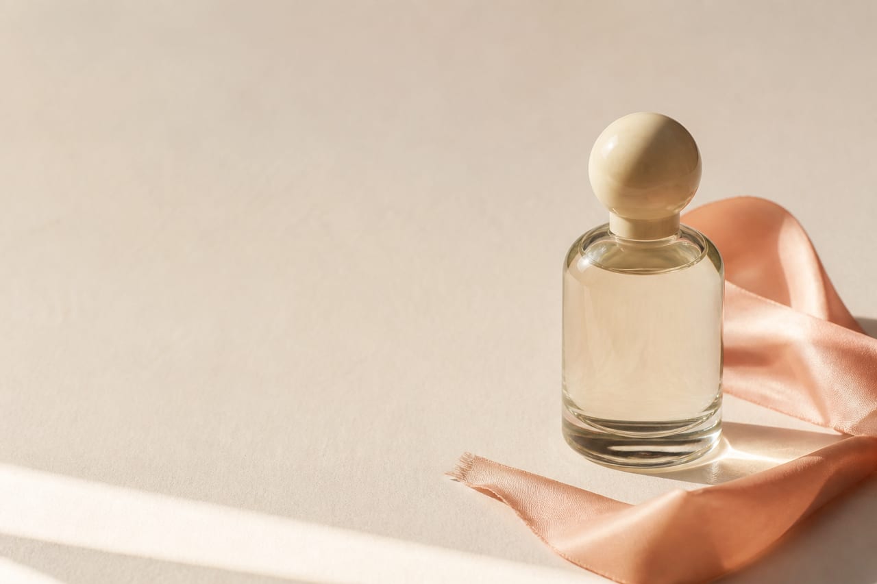 Bodegón editorial de un frasco de perfume crema